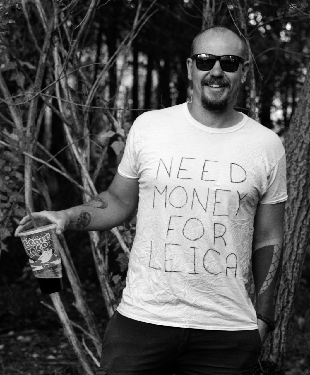 Anton Tishkin wearing sunglasses and a T-shirt reading ‘Need money for Leica’